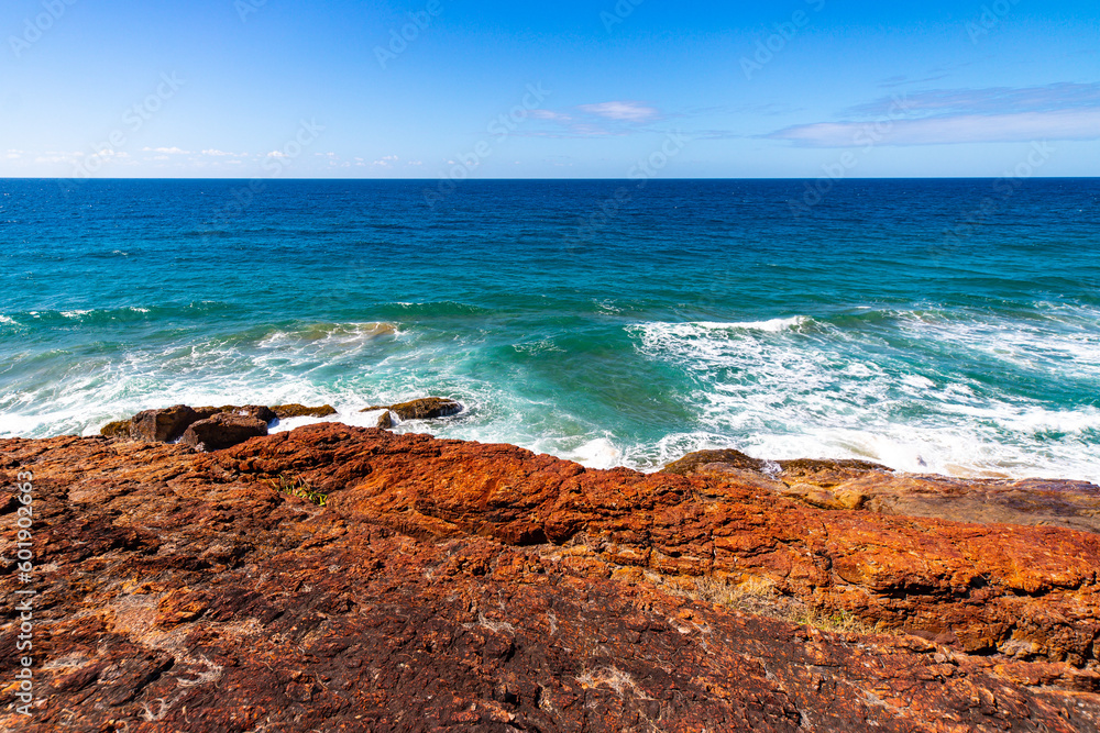 red cliff in deepwater national park near agnes water in queensland, australia; red rocks above turquoise water