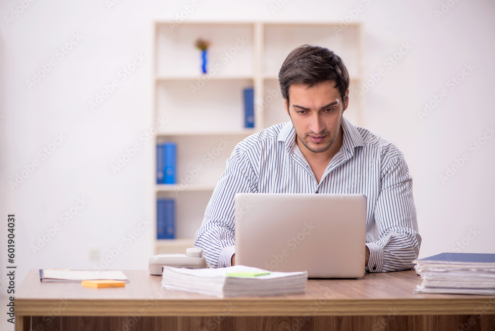 Young male employee working in the office Young male employee working in the office