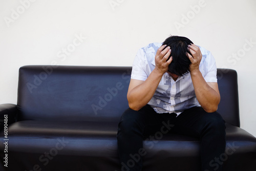 Asian man feels sad, stressed, depressed, hand covered his head. Concept, drepression, failure, disappointment, broken heart. guilty, have life problems. Major Depressive Disorder  photo