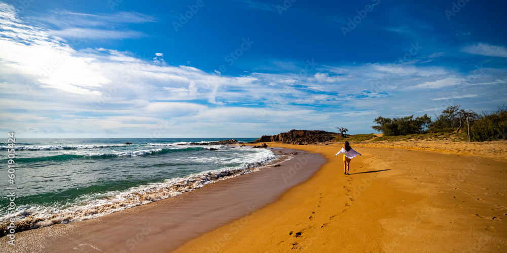 beautiful long hair girl in white shirt walking on a paradise beach in