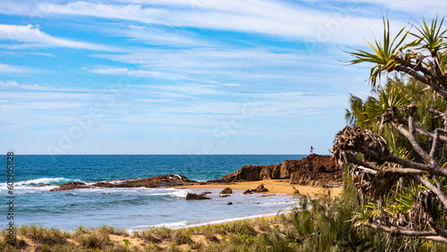 little silhouette of long haired girl standing on the rocks and gazing at the sea at wreck rock beach in deepwater national park near agnes water  queensland  australia