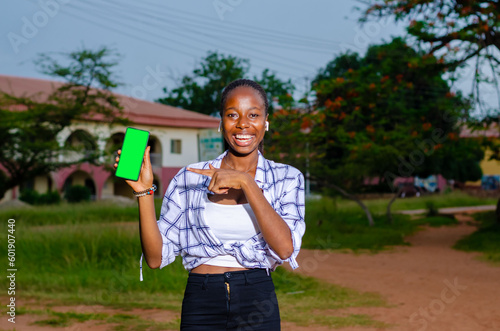Young happy beautiful African woman demonstrates phone with green display admiring new online shopping © Vic Josh