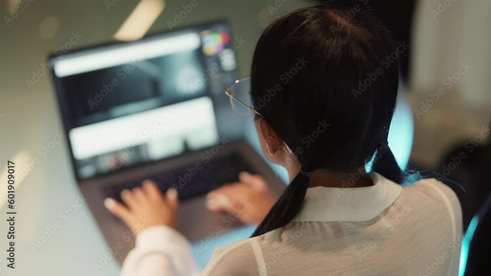 Back View Of A Woman Working At Desk With Her Laptop Back View Of A Woman Working At Desk With Her Laptop