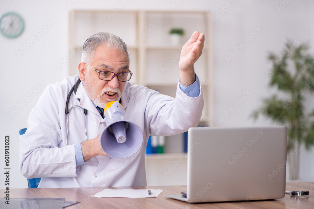 Old male doctor holding megaphone Old male doctor holding megaphone