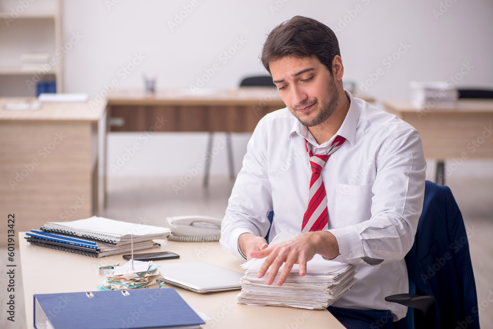 Fototapeta premium Young male employee working in the office