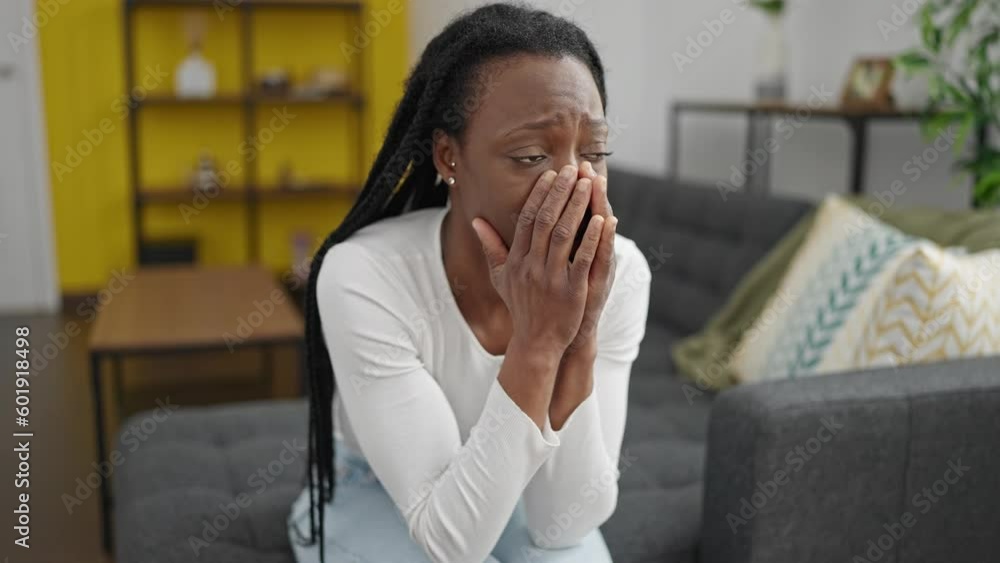 African american woman stressed sitting on sofa at home African american woman stressed sitting on sofa at home