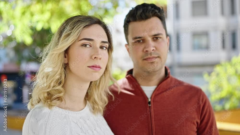 Man and woman couple standing together with relaxed expression at park Man and woman couple standing together with relaxed expression at park