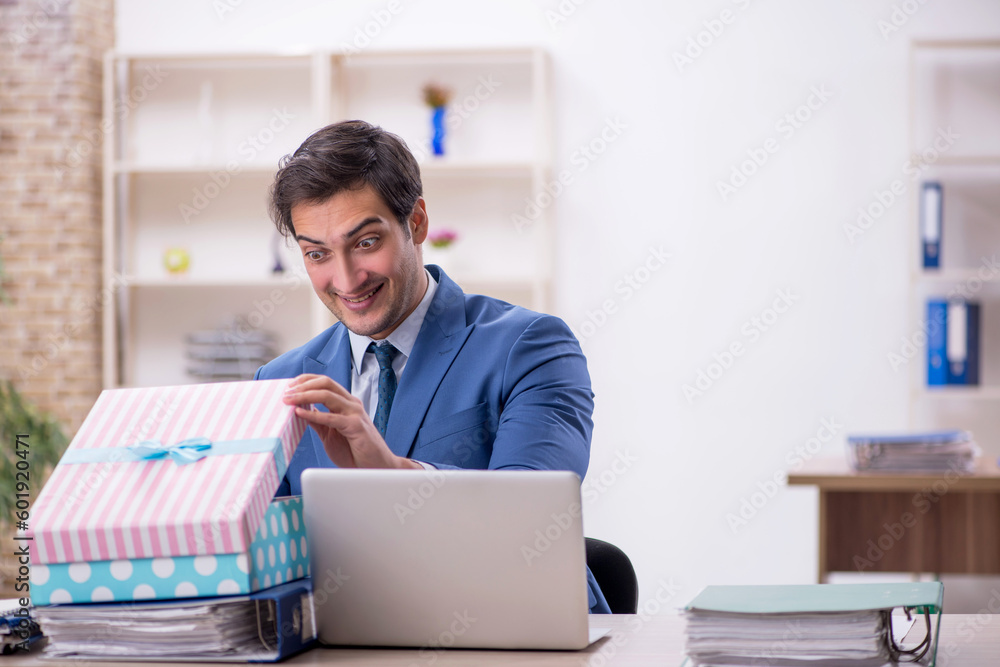 Young male employee celebrating birthday at workplace Young male employee celebrating birthday at workplace