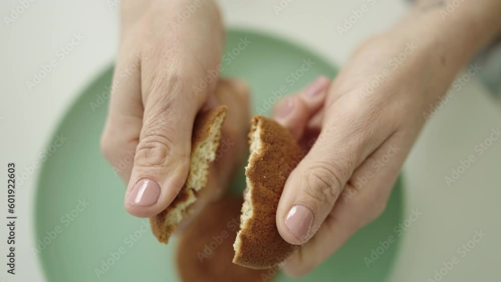 Young beautiful hispanic woman breaking a cookie at dinning room Young beautiful hispanic woman breaking a cookie at dinning room