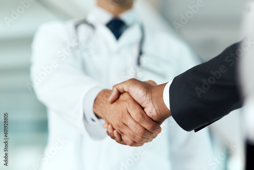 Closeup, doctor or man with handshake, negotiation or planning with partnership, healthcare or wellness. Medical professional, consultant or employee with an offer, support or teamwork with promotion