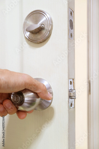 Hand holding steel doorknob for closing the door 