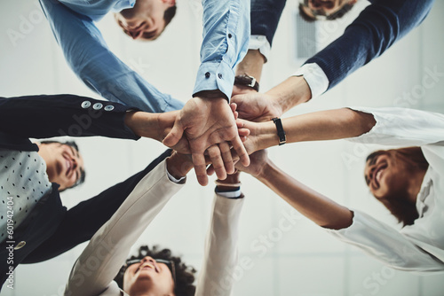 Hands together, business people and solidarity with low angle, support and team huddle with collaboration. Group of employees working in office, teamwork and mission with workforce and hand stack photo