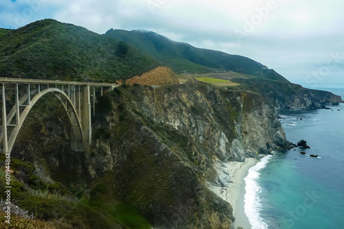 Panoramic view of Bixby Creek Bridge along rugged coastline of Big Sur with Santa Lucia Mountains along famous Highway 1, Monterey county, California, USA, America. Road trip on summer day at seaside