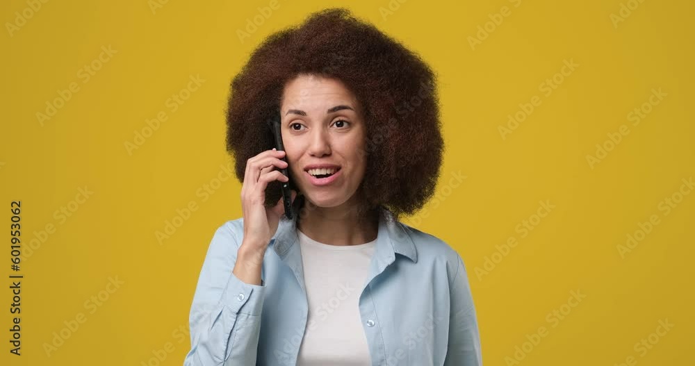 Young beautiful smiling African american woman talking on the phone answering phone call over yellow orange background Young beautiful smiling African american woman talking on the phone answering phone call over yellow orange background