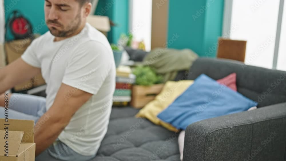 Young hispanic man tired lying on sofa at new home Young hispanic man tired lying on sofa at new home