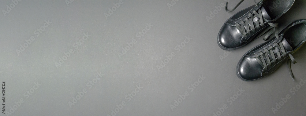 Black leather shoes on a black background. Black sneakers with white laces. New shoes. Horizontal image. Banner for insertion into site. Black leather shoes on a black background. Black sneakers with white laces. New shoes. Horizontal image. Banner for insertion into site.