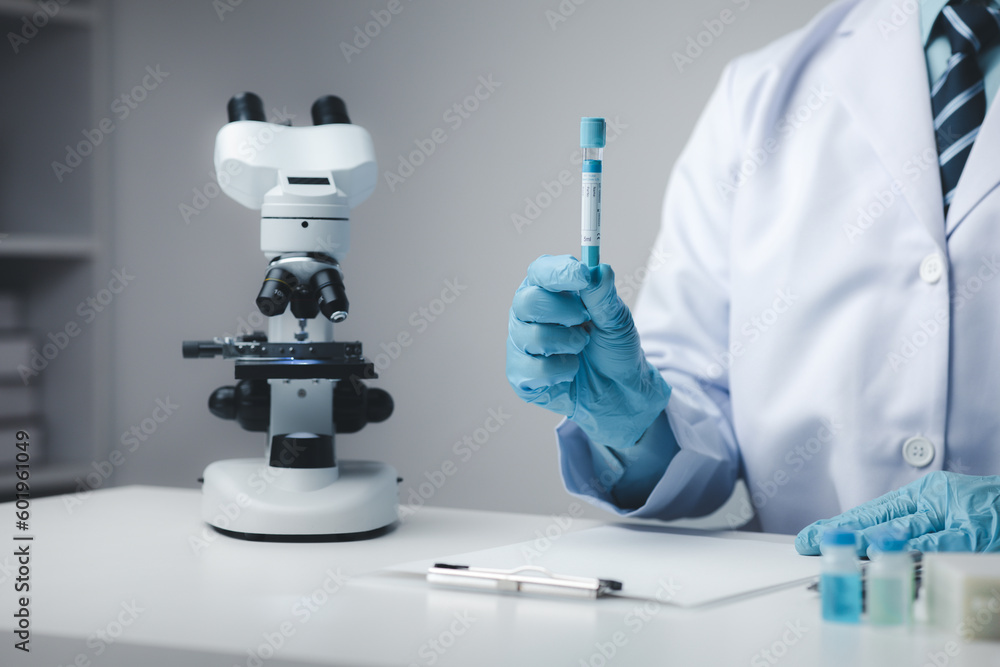 Lab assistant, medical scientist, chemistry researcher holds a glass tube through a chemical test tube, does a chemical experiment and examines a patient's sample. Medicine and research concept. Lab assistant, medical scientist, chemistry researcher holds a glass tube through a chemical test tube, does a chemical experiment and examines a patient's sample. Medicine and research concept.