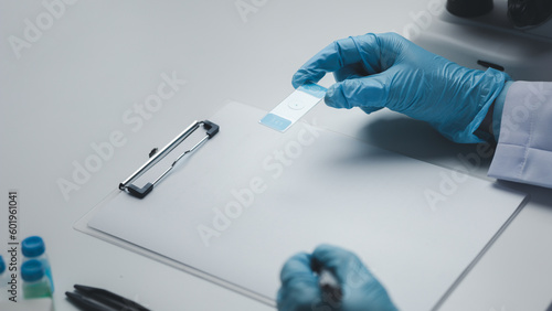 Lab assistant, medical scientist, chemistry researcher holds a glass tube through a chemical test tube, does a chemical experiment and examines a patient's sample. Medicine and research concept.