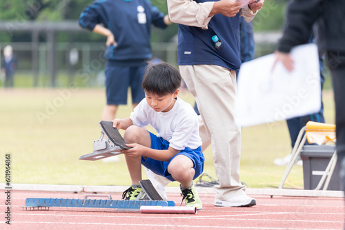 陸上競技大会でスタートの準備をする小学生の男の子 photo
