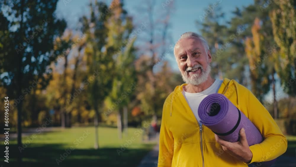 Portrait of happy senior man holding fitness mat, outdoor gym, morning training Portrait of happy senior man holding fitness mat, outdoor gym, morning training
