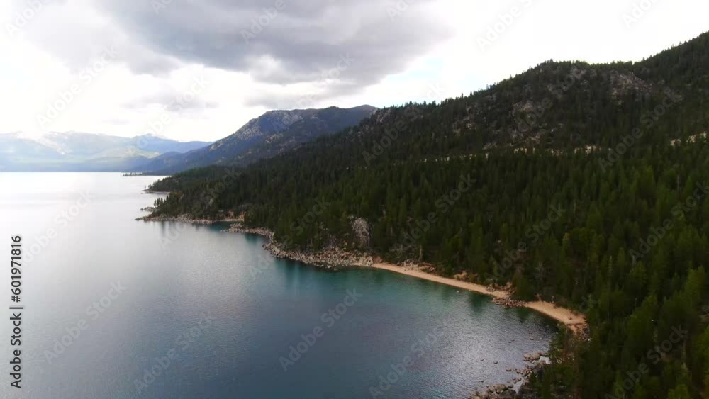 Aerial cinematic drone stunning Lake Tahoe of Hidden Chimney Beach Sand Harbor Beach cloudy deep blue boulders spring summer beautiful daytime highway 28 California Nevada backward to left movement Aerial cinematic drone stunning Lake Tahoe of Hidden Chimney Beach Sand Harbor Beach cloudy deep blue boulders spring summer beautiful daytime highway 28 California Nevada backward to left movement