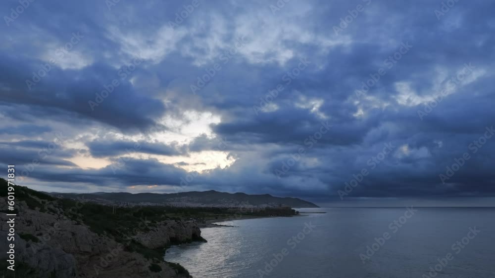 Dramatic Time-Lapse Shot of Clouds Over Rocky Coastline at Dawn in Sitges, Spain Dramatic Time-Lapse Shot of Clouds Over Rocky Coastline at Dawn in Sitges, Spain