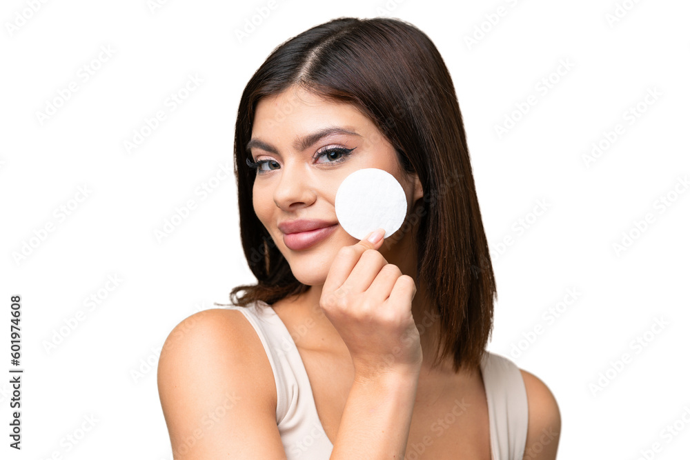 Young Russian woman with rainproof coat and umbrella over isolated chroma key background with cotton pad for removing makeup from her face