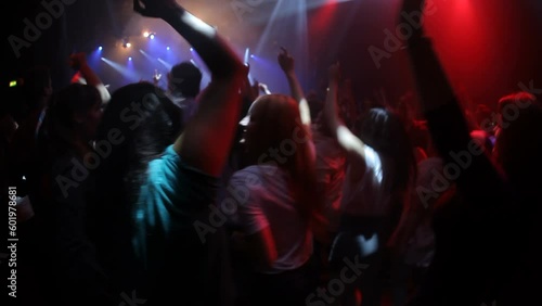 Audience, party or music crowd in concert for dance, live performance or celebration at rock band festival. Event, lights or edm disco people wave hands, having fun and dancing with friends at night photo
