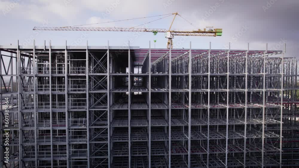 The metal framework for a constructing building. A large crane can be seen in the background. The metal framework for a constructing building. A large crane can be seen in the background.