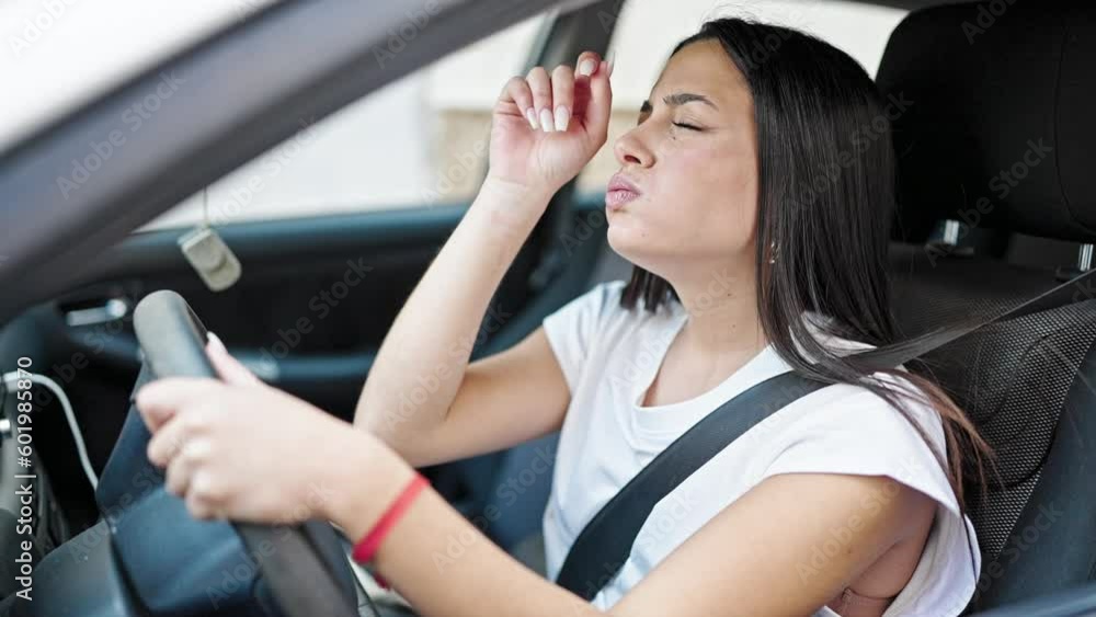 Young beautiful hispanic woman tired driving car yawning at street Young beautiful hispanic woman tired driving car yawning at street