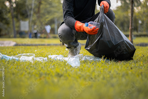 Quadro em tela Man picking up plastic bottle, garbage collecting in a forest cleaning planet, h