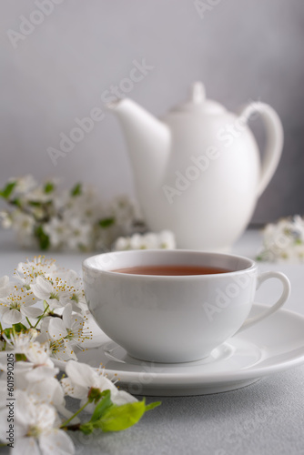A cup of tea on the table with spring cherry blossoming branches
