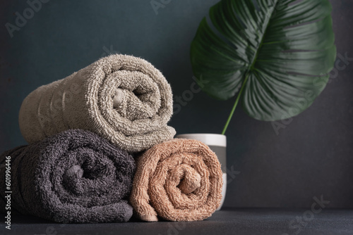 Rolled cotton towels and monstera leaf