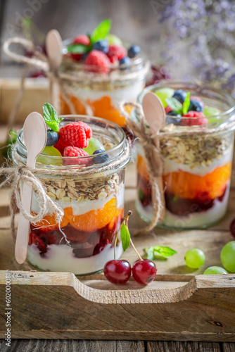 Sweet granola in jar with oat flakes and yoghurt.