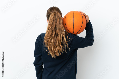 Little caucasian girl isolated on white background playing basketball in back position © luismolinero