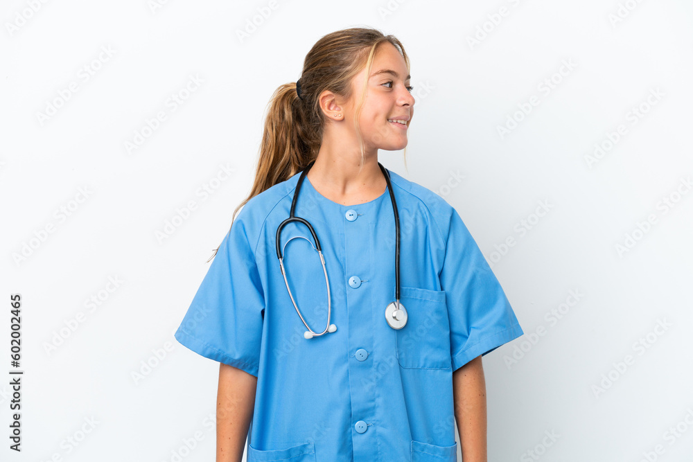 Little caucasian girl disguised as surgeon isolated on white background looking side Little caucasian girl disguised as surgeon isolated on white background looking side