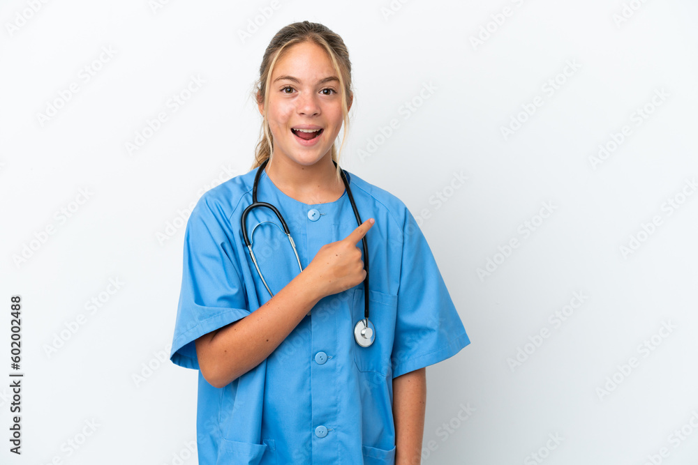 Little caucasian girl disguised as surgeon isolated on white background surprised and pointing side Little caucasian girl disguised as surgeon isolated on white background surprised and pointing side