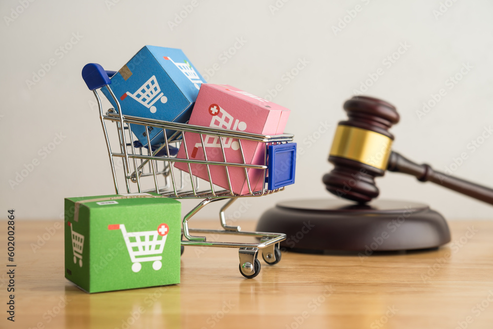 Trolley, online shopping boxes and hammer judge gavel on wooden background. Consumer rights and responsibilities to safety, customer protection in online shopping e-commerce, commercial law concept. - obrazy, fototapety, plakaty 