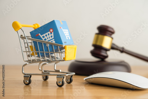 Фотография Trolley, mouse, online shopping boxes and hammer judge on wooden background
