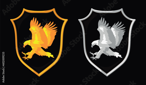 Heraldic shield with wings. Golden & silver eagle hunting. Isolated vector. Concept art. Logo.