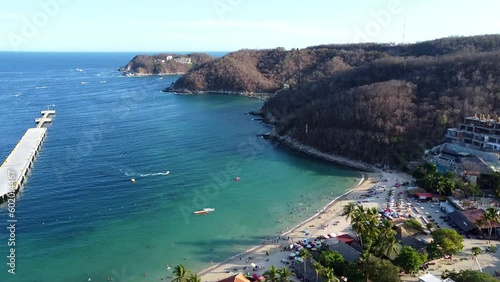 4k aerial view drone of a beach in mexico summer holidays huatulco oaxaca with boats in the water and a blue sky photo