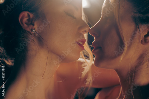 Couple of young blonde women approaching for a romantic kiss (5/6)