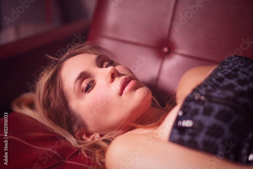 Close-up of a delicate blonde woman posing on a red vintage couch (7/8)