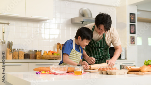 Foto Happy Young Asian father and son cooking in kitchen at home