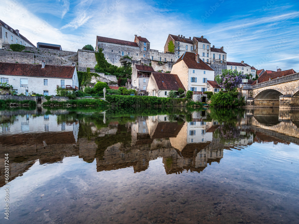 The medieval walled city of Pesmes in Burgundy. Reflection in the river at sunset.