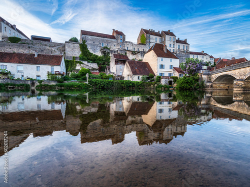 The medieval walled city of Pesmes in Burgundy. Reflection in the river at sunset.