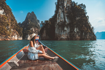 Traveler asian woman relax and travel on Thai longtail boat in Ratchaprapha Dam at Khao Sok National Park Surat Thani Thailand