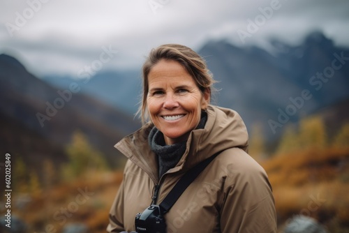 Portrait of a smiling mature woman with backpack hiking in the mountains © Robert MEYNER