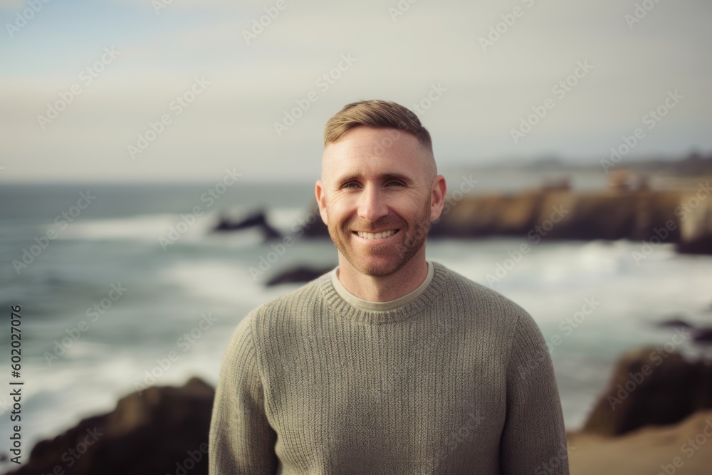 Portrait of smiling man standing by the ocean at the beach on a sunny day Portrait of smiling man standing by the ocean at the beach on a sunny day