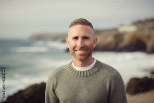 Portrait of handsome man standing at beach on a sunny winters day © Robert MEYNER